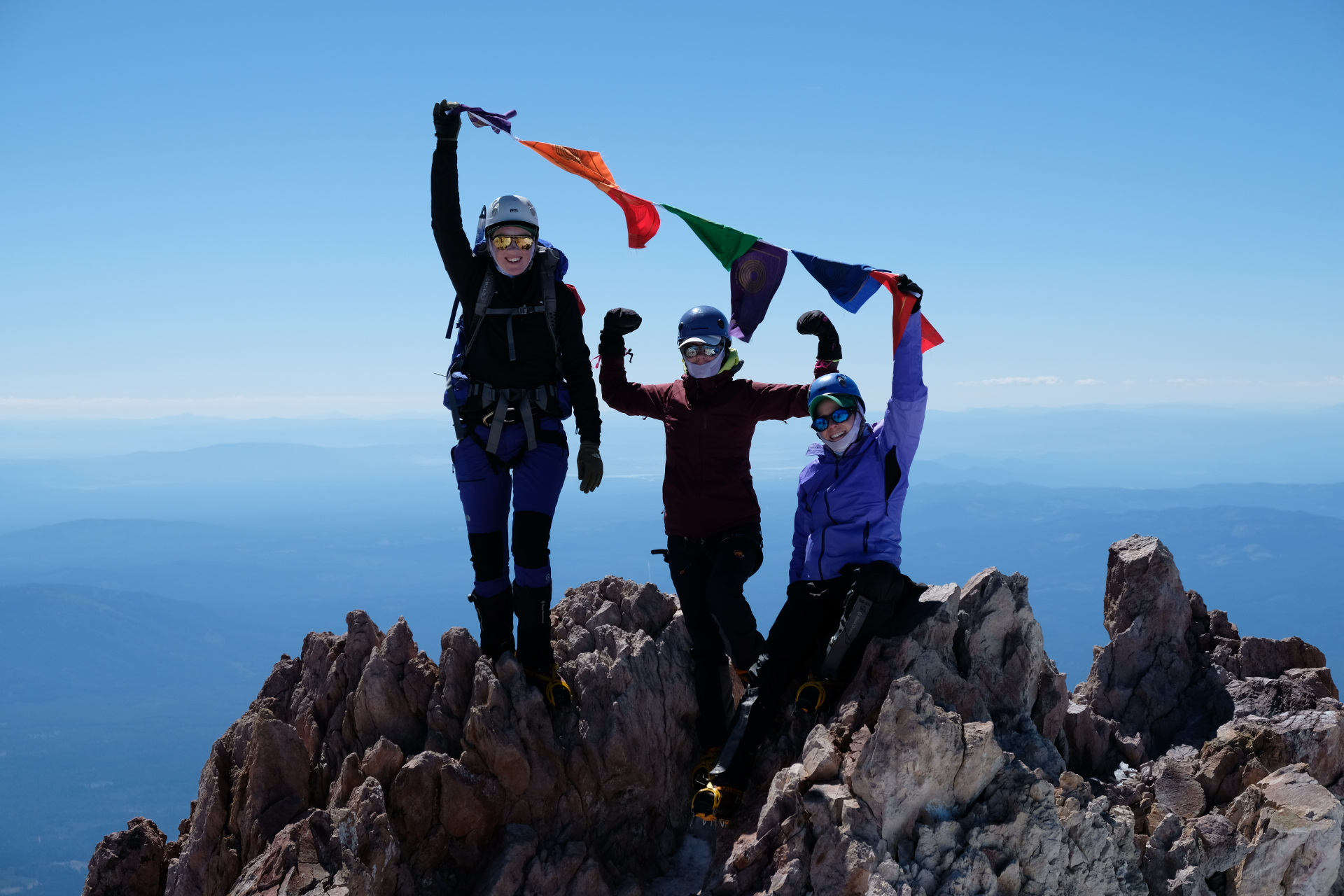 At the top of Mount Shasta, Climb Against the Odds climbers fly prayer flags in honor and memory of those affected by breast cancer and other diseases