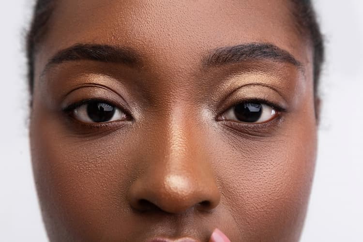 beautiful dark skinned woman with golden eye shadow close up face