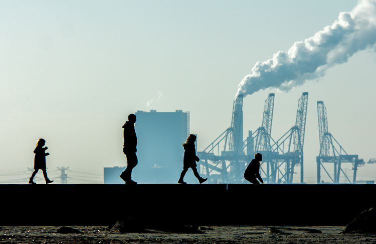 family-walking-in-front-of-smoke-stacks_istock_BCPP