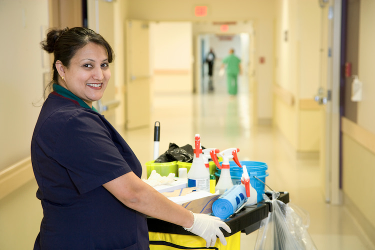 Female janitor with cleaning supplies occupational hazard