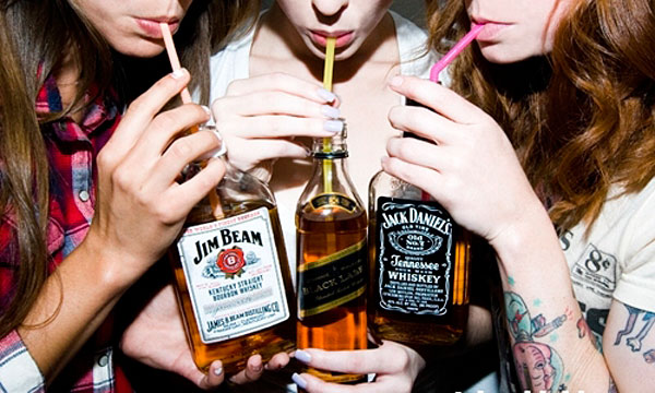 young women drinking whiskey from bottles