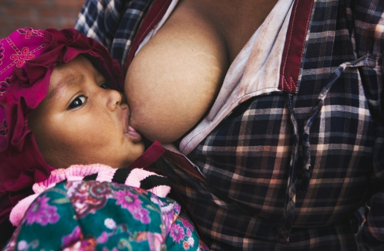 Breastfeeding mother feeds baby