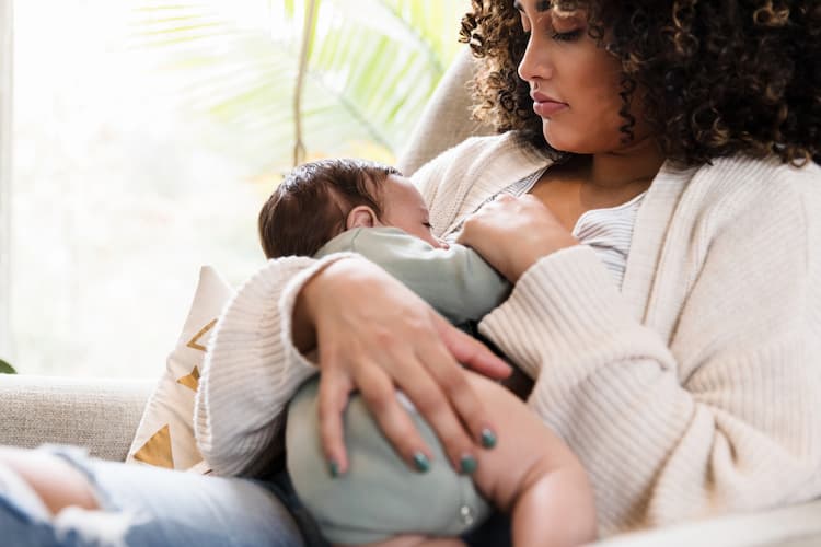 breastfeeding mama holds baby