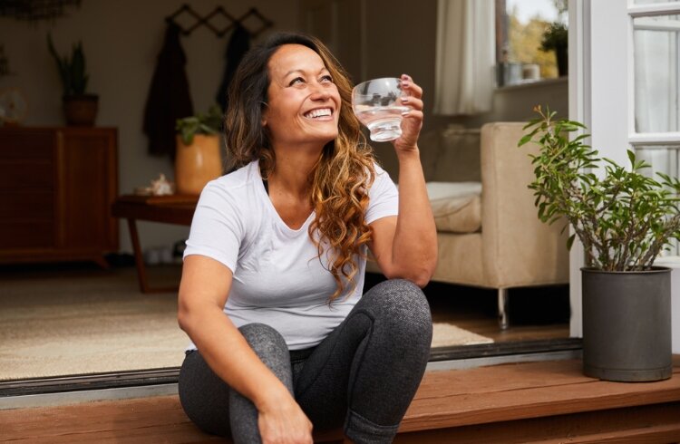 woman holds drinking water glass in hand