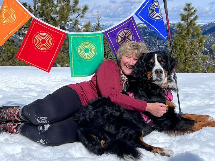 Dana with dog in front of prayer flags